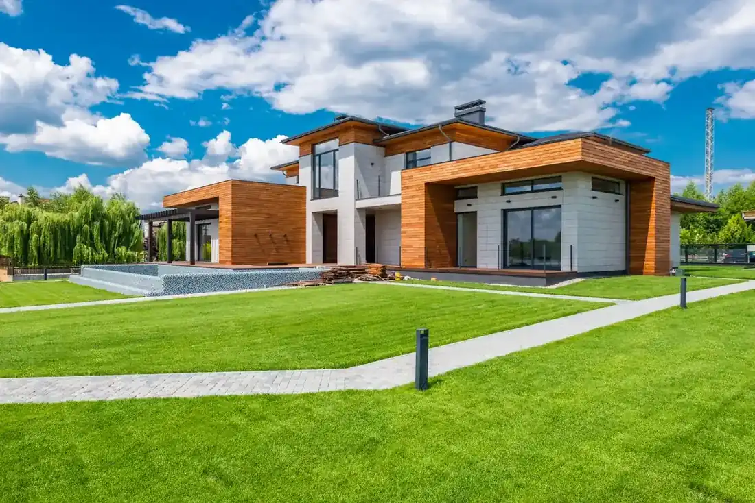 Modern custom-built home with wood paneling, stone walls, and a pool